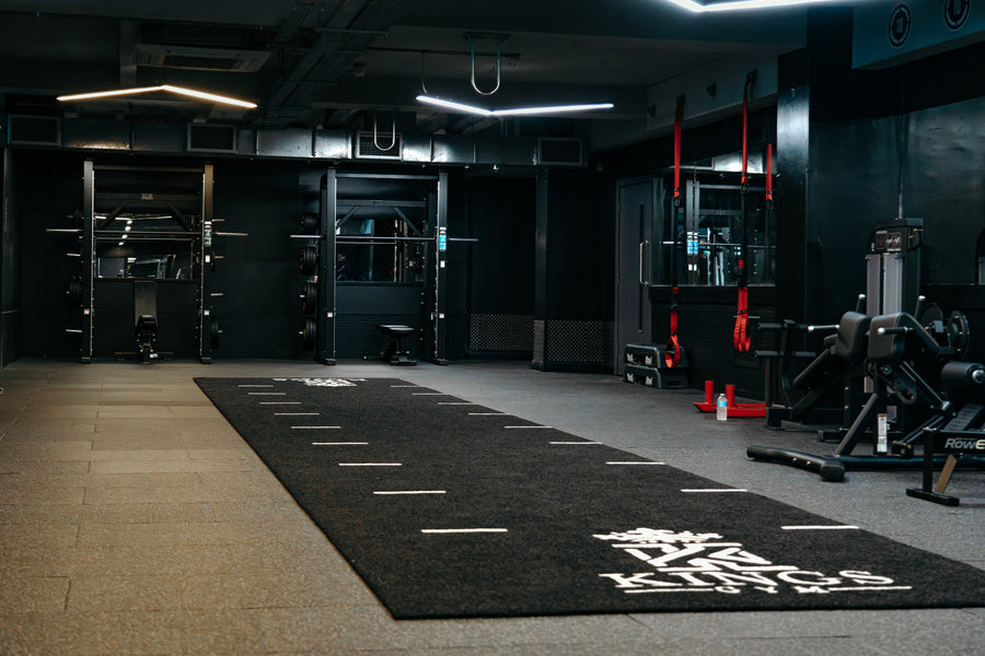 Power racks and a sled track with the Kings Gym logo at Kings Gym Brighton